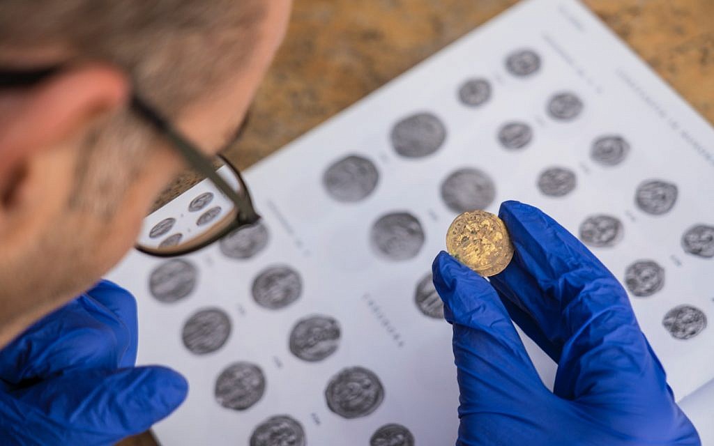 Preliminary identification of the coins discovered at the Caesarea Maritima archaeological site by (left) Dr. Robert Kool, coin expert at the Israel Antiquities Authority (Yaniv Berman, courtesy of the Caesarea Development Corporation)