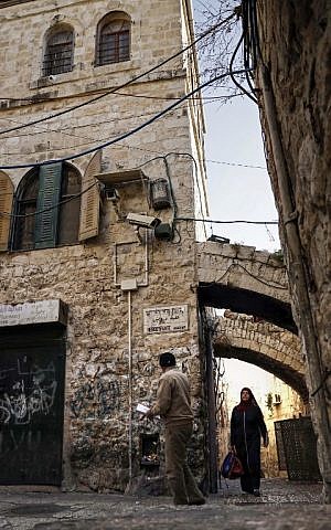 Palestinians walk past a house in the Muslim Quarter of the Old City of Jerusalem which was bought by Jewish Israelis, on December 4, 2019. (THOMAS COEX/AFP)