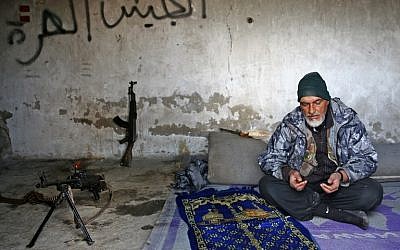 A Turkey-backed Syrian fighter recites a prayer in the town of Qirata, near the rebel-held border town of Jarabulus, on December 24, 2018. (Nazeer AL-KHATIB / AFP)