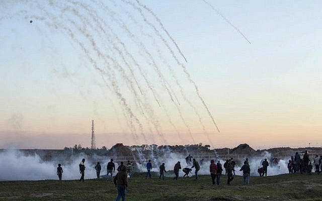 Tear gas canisters falling amidst Palestinian protesters during clashes with Israeli forces across the border fence, east of Gaza City, January 18, 2019. (SAID KHATIB / AFP)
