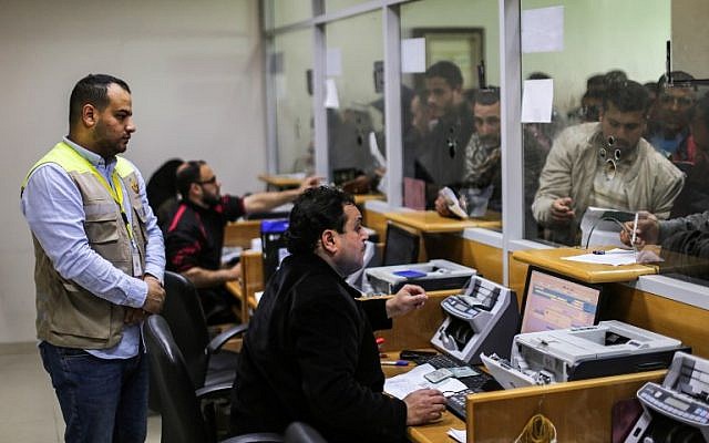 Illustrative: Postal workers help Palestinians, who arrived at the central post office in Gaza City on January 26, 2019, to receive financial aid from the Qatari government given to impoverished families. (Mahmud Hams/AFP)
