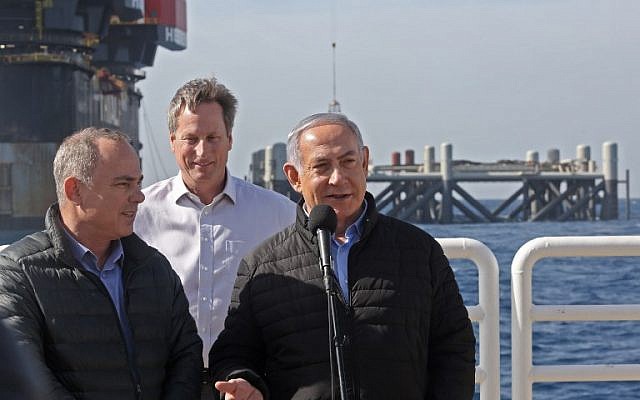 Prime Minister Benjamin Netanyahu, right, speaks alongside Energy Minister Yuval Steinitz, left, and Noble Energy's Vice President for Major Projects George Hatfield, center, during the inauguration of the newly-arrived foundation platform for the Leviathan natural gas field in the Mediterranean Sea, January 31, 2019. (Marc Israel Sellem/Pool/AFP)