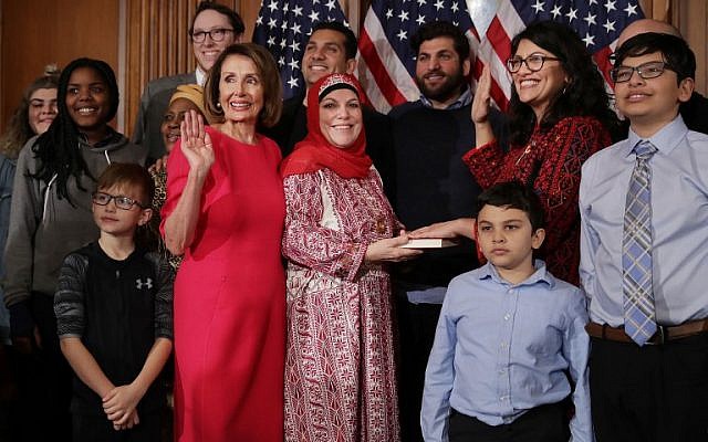 Rashida Tlaib (in red thobe and glasses), accompanied by her family, being sworn in with Speaker of the House Nancy Pelosi (in pink dress), at the US Capitol in Washington, DC, January 3, 2019. (Chip Somodevilla/Getty Images/AFP)