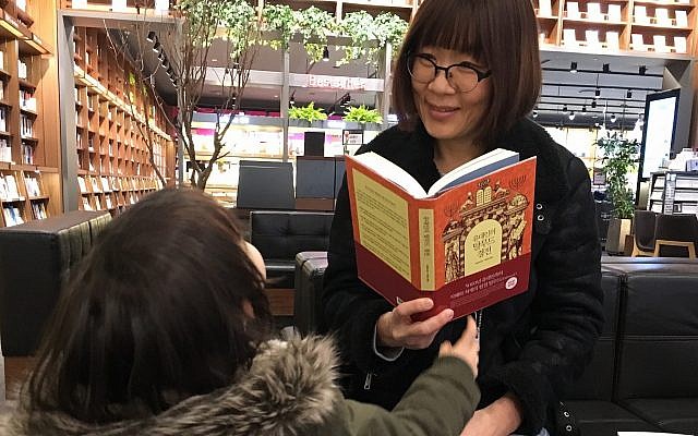 A South Korean woman and her child read Talmud-themed books at a Seoul bookstore. (Tim Alper via JTA)