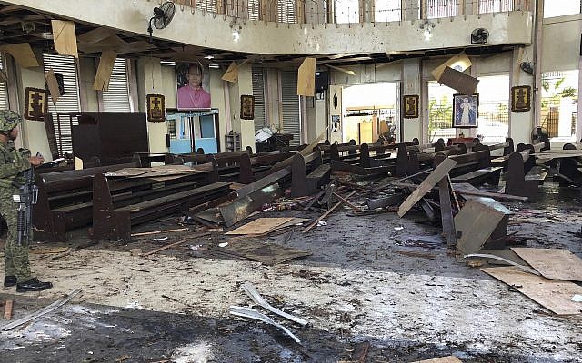 In this photo provided by WESMINCOM Armed Forces of the Philippines, a soldier views the site inside a Roman Catholic cathedral in Jolo, the capital of Sulu province in the southern Philippines after two bombs exploded January 27, 2019. (WESMINCOM Armed Forces of the Philippines Via AP)