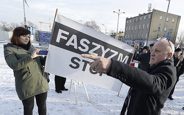 A Polish far-right activist, Piotr Rybak,right, and other nationalists gather outside the memorial site of Auschwitz in Oswiecim, Poland, on Sunday Jan. 27, 2019. (AP Photo/Czarek Sokolowski)