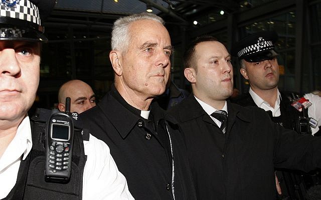 Bishop Richard Williamson, second from left in foreground, is escorted out of Heathrow airport by police and security officers after arriving on a flight from Argentina, in London, Feb. 25, 2009 (AP Photo/Kirsty Wigglesworth)