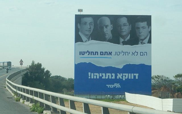 An election campaign poster for the Likud party featuring journalists (L-R) Raviv Drucker, Guy Peleg, Amnon Abramovich and Ben Caspit, saying, "They will not decide. You will decide" in central Israel, January 20, 2019. (Twitter)