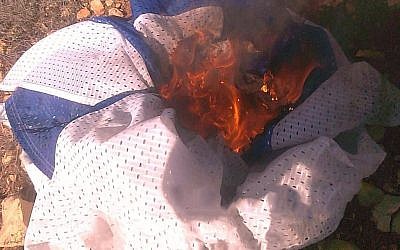 A photo released on January 6, 2019 by the Shin Bet, saying it is a screenshot from a video showing an Israeli flag being burned by Jewish teens suspected of murdering a Palestinian woman in the West Bank. (Shin Bet)