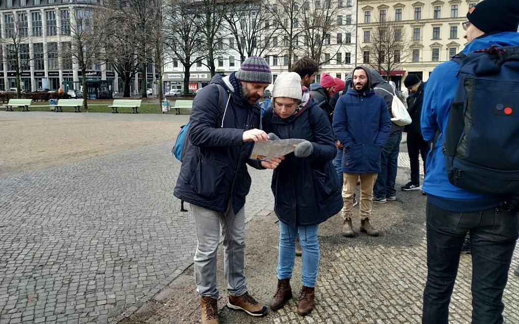 Organizers Ben Fisher, left, and Anne Aulinger map out where in Berlin's Kreuzberg neighborhood different groups will clean stolpersteine on international Holocaust Remembrance Day, January 27, 2019. (Yaakov Schwartz/Times of Israel)