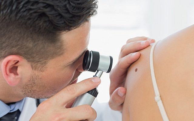 Illustrative image of a dermatologist checking a mole (Wavebreakmedia; iStock by Getty Images)
