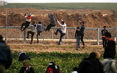 Palestinians climb the security fence along the border between Israel and the Gaza Strip, during clashes east of Gaza City, on February 15, 2019. (Said Khatib/AFP)