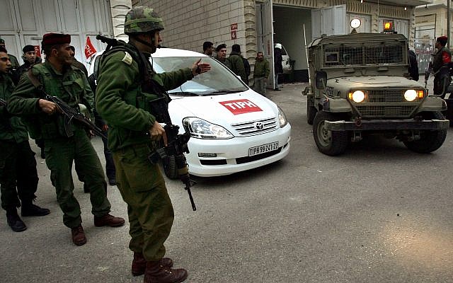 Soldiers stand near a car used by members of the TIPH, Temporary International Presence in Hebron on Wednesday, Feb. 8, 2006. (AP Photo/Emilio Morenatti)