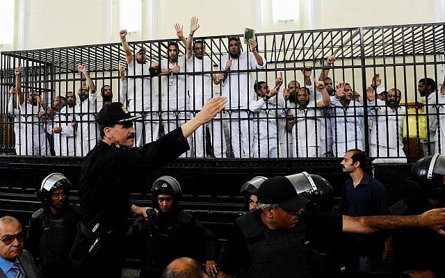 Illustrative: Supporters of the Muslim Brotherhood and other Islamists gesture from the defendants cage as they receive sentences in a mass trial in Alexandria, Egypt, on May 19, 2014. (AP Photo/Heba Khamis)