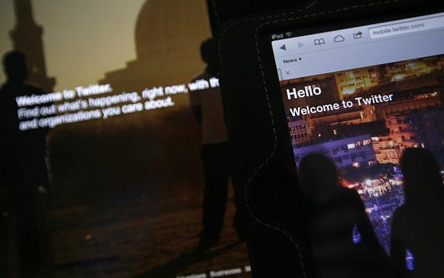 In this July 31, 2013 photo, the home page for Twitter is displayed on an iPad and a laptop computer. (AP Photo/Alastair Grant)