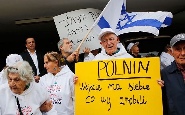 Holocaust survivors hold banners and wave an Israeli flag during a protest in front of Polish embassy in Tel Aviv on February 8, 2018, against a controversial bill (GIL COHEN-MAGEN/AFP/Getty Images)
