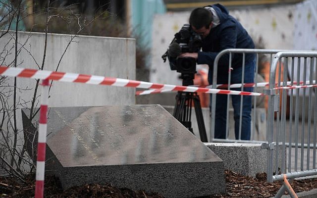 A cameraman films the memorial stone marking the site of Strasbourg's Old Synagogue, which was destroyed by the Nazis in World War II, after it was vandalized overnight on March 2, 2019 in Strasbourg, eastern France (FREDERICK FLORIN / AFP)