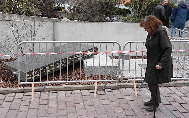 A person passes by the memorial stone marking the site of Strasbourg's Old Synagogue, which was destroyed by the Nazis in World War II, after it was vandalised overnight on March 2, 2019 in Strasbourg, eastern France. (FREDERICK FLORIN / AFP)