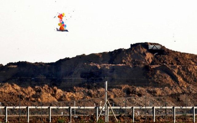 Illustrative: Balloons carry a makeshift drone-shaped object flying over the border with Israel east of Gaza City, after it was set loose by Palestinians during a protest by the fence, on March 22, 2019. (Said Khatib/AFP)