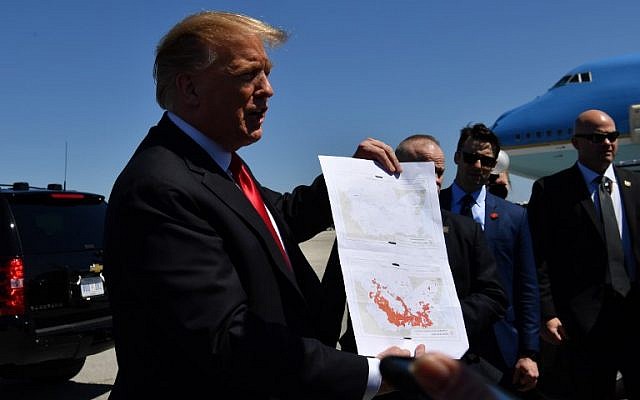 US President Donald Trump shows a map which he said indicates the end of ISIS, as he arrives at Palm Beach International Airport in Florida on March 22, 2019. (Photo by Nicholas Kamm / AFP)