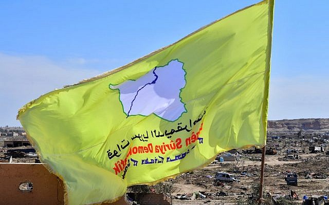 A picture taken on March 23, 2019 shows the US-backed Syrian Democratic Forces' (SDF) flag atop a building in the Islamic State group's last bastion in the eastern Syrian village of Baghouz after defeating the jihadist group (Giuseppe CACACE / AFP)