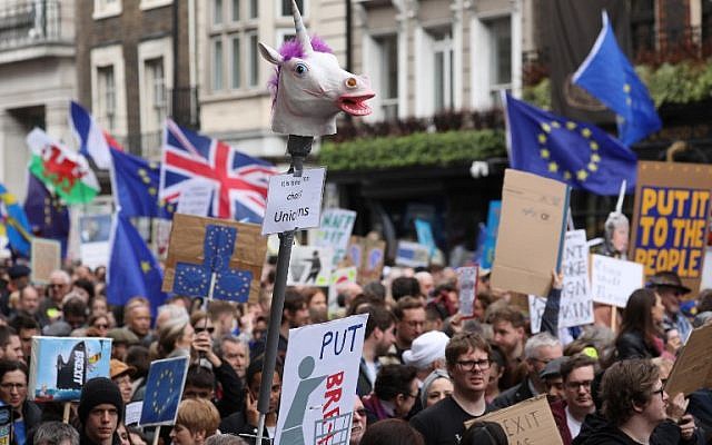 People hold up placards and European flags as they attend a march and rally organised by the pro-European People's Vote campaign for a second EU referendum in central London on March 23, 2019. (Isabel INFANTES / AFP)