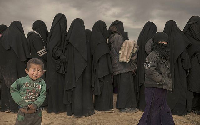 Women and children stand in line at a reception area for people evacuated from the last shred of territory held by Islamic State militants, outside Baghouz, Syria, on March 6, 2019. (AP/Gabriel Chaim)