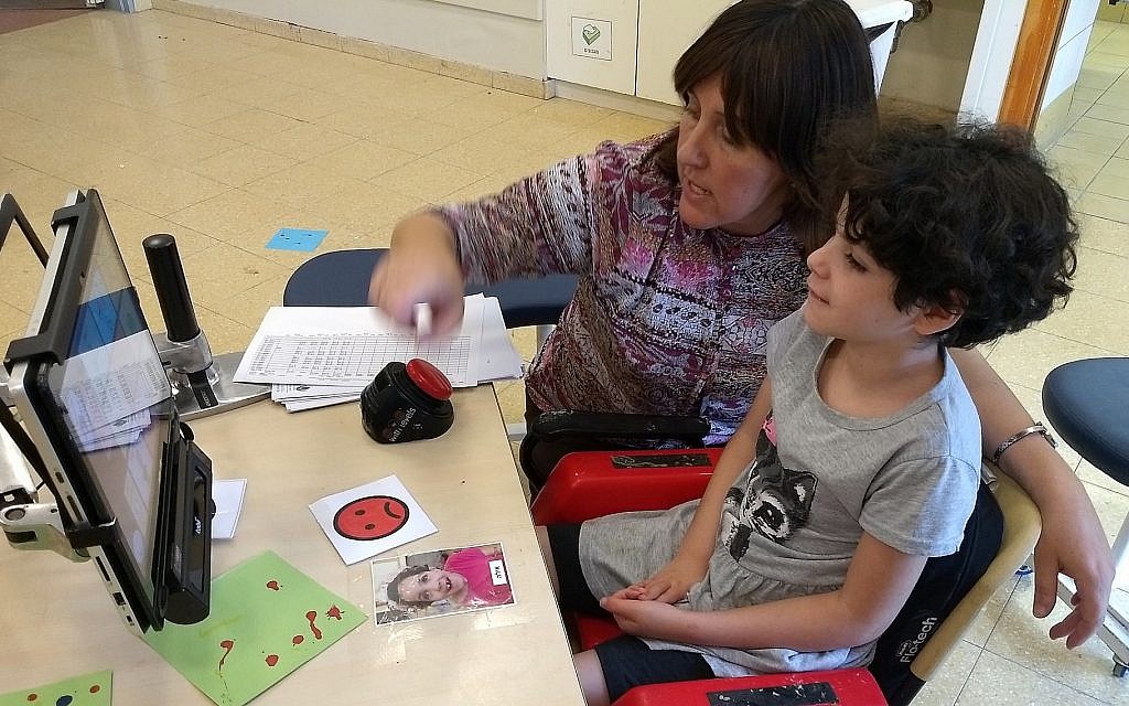 Ayala, 11, a student with a cognitive disability, communicates via a computer screen with her teacher, Rivka Dimant, in a school at Aleh Negev, a campus for Israelis with disabilities, October 25, 2018. (Ben Sales via JTA)