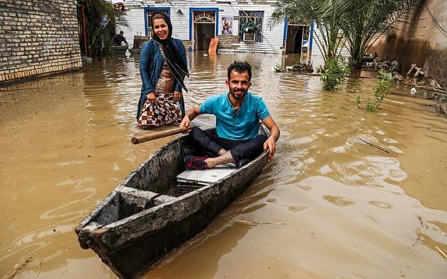 An Iranian man sits in a boat at his flooded garden in a village around the city of Ahvaz, in Iran’s Khuzestan province, on April 1 2019. (Mehdi PEDRAMKHOO / TASNIM NEWS / AFP)