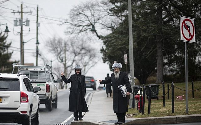 Illustrative: This picture taken on April 5, 2019 shows shows two Jewish men hitchhiking during a rainfall in a Jewish neighborhood of Monsey in Rockland County, New York. (Johannes Eisele/AFP)
