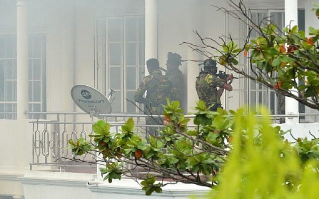 Sri Lankan Special Task Force (STF) personnel are pictured outside a house during a raid -- after a suicide blast had killed police searching the property -- in the Orugodawatta area of the capital Colombo on April 21, 2019, following a series of blasts in churches and hotels. (ISHARA S. KODIKARA / AFP)