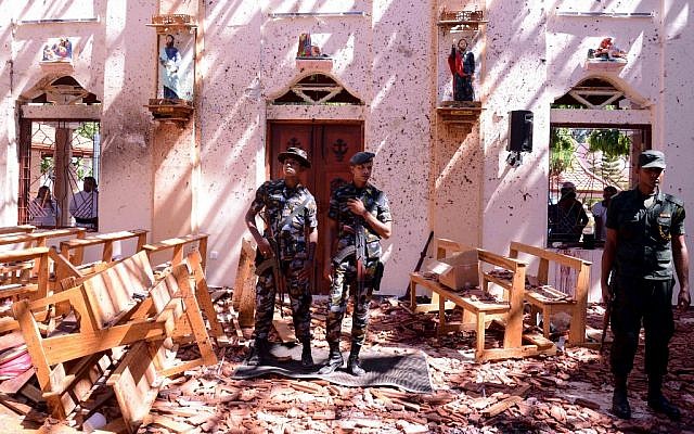 Los soldados de Sri Lanka observan el interior de la Iglesia de San Sebastián en Katuwapitiya en Negombo el 21 de abril de 2019, luego de una explosión de bomba durante el servicio de Pascua que mató a decenas de personas.  (STR / AFP)