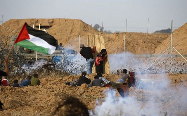 Palestinian protesters use a makeshift shield during a demonstration near the border with Israel, east of Khan Yunis in the southern Gaza Strip, on April 26, 2019. (Said KHATIB / AFP)