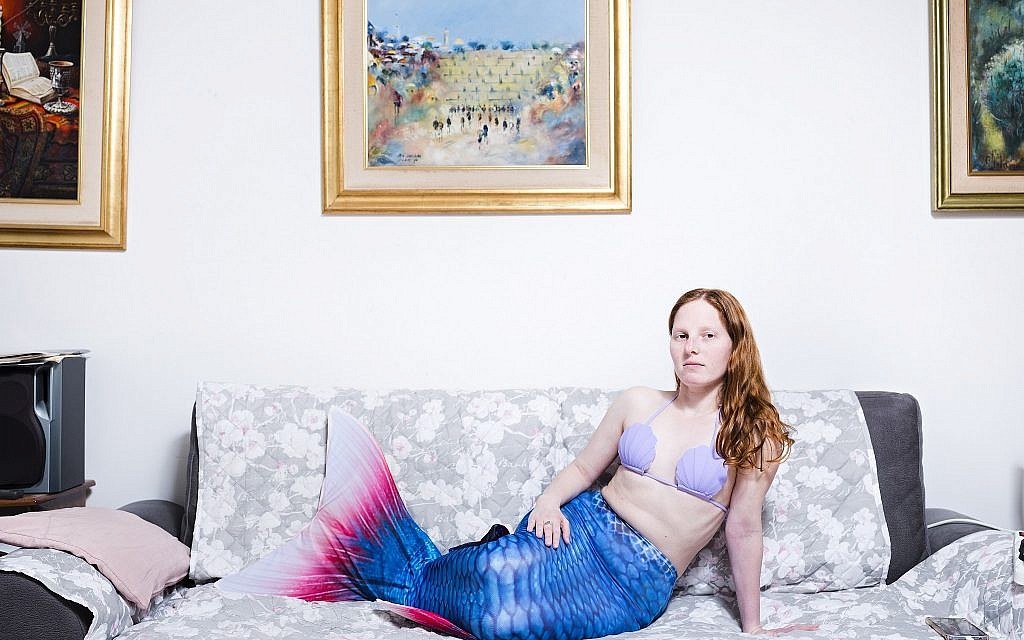 In this Tuesday, March. 26, 2019 photo, Vered Klein, a member of the Israeli Mermaid Community, poses for a portrait as she wears a mermaid tail at her home in Ramat Gan, Israel. (AP Photo/Oded Balilty)