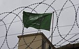 Illustrative: A Saudi flag behind barbed wire (AP Photo/Petros Giannakouris)