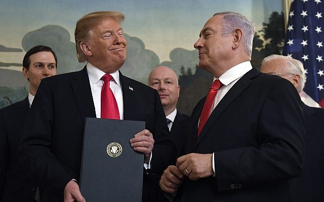 US President Donald Trump smiles at Israeli Prime Minister Benjamin Netanyahu, right, after signing a proclamation formally recognizing Israel's sovereignty over the Golan Heights, in the Diplomatic Reception Room at the White House, in Washington, DC, on March 25, 2019. (AP/Susan Walsh)