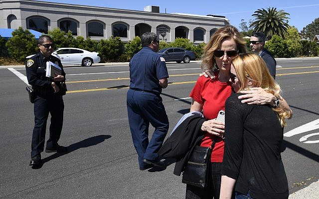 Jessica Parks, right, hugs Tina White outside of the Chabad of Poway Synagogue Saturday, April 27, 2019, in Poway, Calif. Several people were injured in a shooting at the synagogue. (AP/Denis Poroy)
