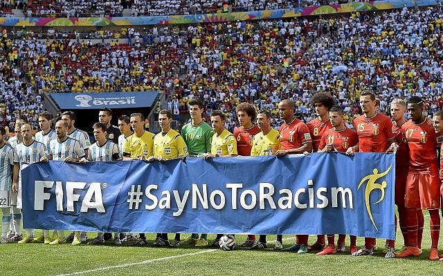 Argentina, left, and Belgium players pose with an anti-racism banner before the World Cup quarterfinal soccer match between Argentina and Belgium at the Estadio Nacional in Brasilia, Brazil, Saturday, July 5, 2014. (AP/Martin Meissner)