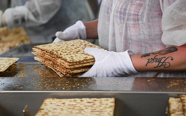 Illustrative: Workers prepare matzah, the unleavened bread eaten during the Jewish holiday of Passover, at the Aviv Matzah plant in Bnei Brak on April 14, 2019. (Flash90)