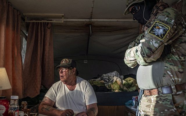 Larry Hopkins, seated, also known as Striker, the leader of the United Constitutional Patriots New Mexico Border Ops militia, inside the team's camper near the US-Mexico border in Anapra, New Mexico, March 20, 2019. (Paul Ratje/AFP/Getty Images via JTA)