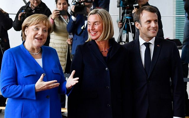 German Chancellor Angela Merkel (L) and French President Emmanuel Macron (R) greet EU's High representative for foreign affairs and security policy Federica Mogherini (C) as she arives at the chancellery in Berlin on April 29, 2019 for the West Balkans conference (John MACDOUGALL / AFP)