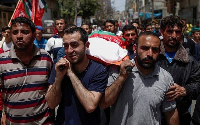 Relatives carry the body of a Palestinian, who was killed in Israeli strikes the previous day, during a funeral ceremony in Beit Lahia, in northern Gaza Strip on May 6 2019. (MAHMUD HAMS / AFP)