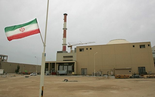 In this file photo from April 3, 2007, an Iranian flag flutters outside the building housing the reactor of the Bushehr nuclear power plant in the Iranian port town of Bushehr. (Behrouz Mehri/AFP)