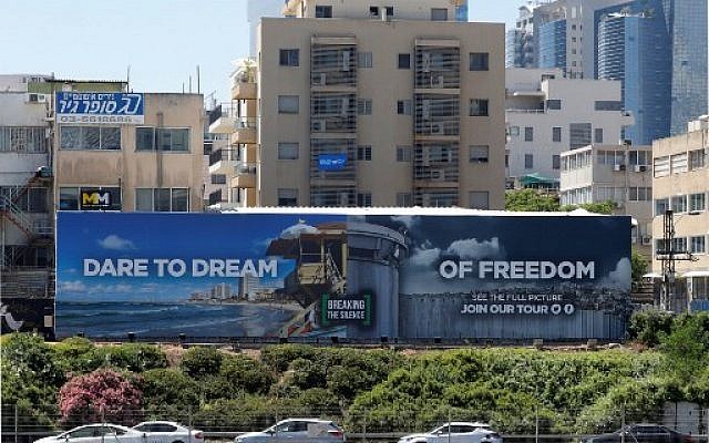 A picture taken on May 13, 2019, shows an anti-occupation billboard, by Israeli NGO Breaking The Silence, erected on a street in the Israeli coastal city of Tel Aviv. (Photo by JACK GUEZ / AFP)