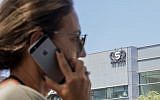 An Israeli woman uses her phone in front of a building in Herzliya that housed the NSO Group intelligence firm, August 28, 2016. (Jack Guez/AFP/File)