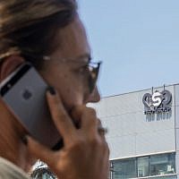 An Israeli woman uses her phone in front of a building in Herzliya that housed the NSO Group intelligence firm, August 28, 2016. (Jack Guez/AFP/File)