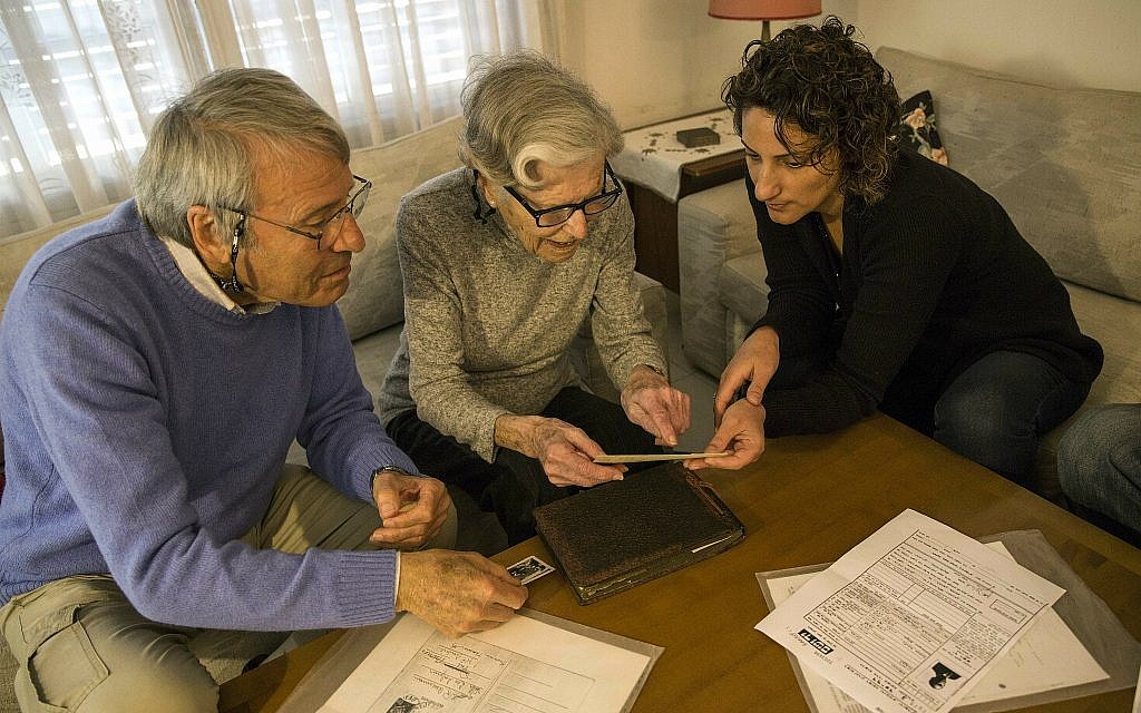 In this photo from April 23, 2019, Israeli Holocaust survivors Rachel Zeiger 91, center, and her brother Moshe Akerman 84, left, speak with Orit Noiman, head of Yad Vashem's collection and registration center, at their home in the Tel Aviv suburb of Ramat Gan. (AP Photo/Tsafrir Abayov)