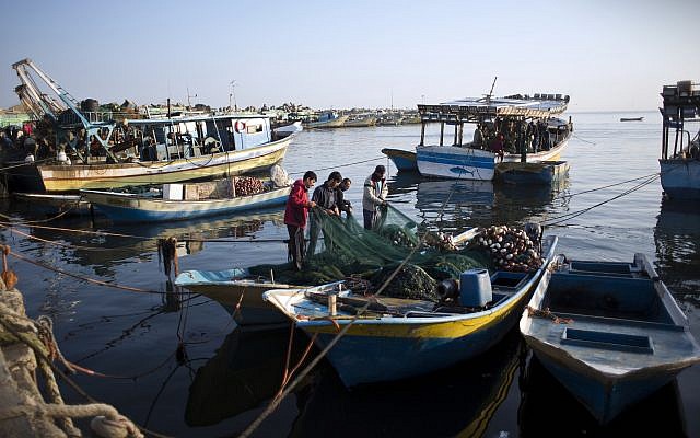 Palestinian fishermen clean a net after a night fishing trip, in the Gaza Seaport on April 3, 2019. (AP Photo/Khalil Hamra)