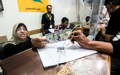 Palestinians receive their financial aid as part of $480 million in aid allocated by Qatar, at a post office in Gaza City on May 19, 2019. (Abed Rahim Khatib/Flash90)