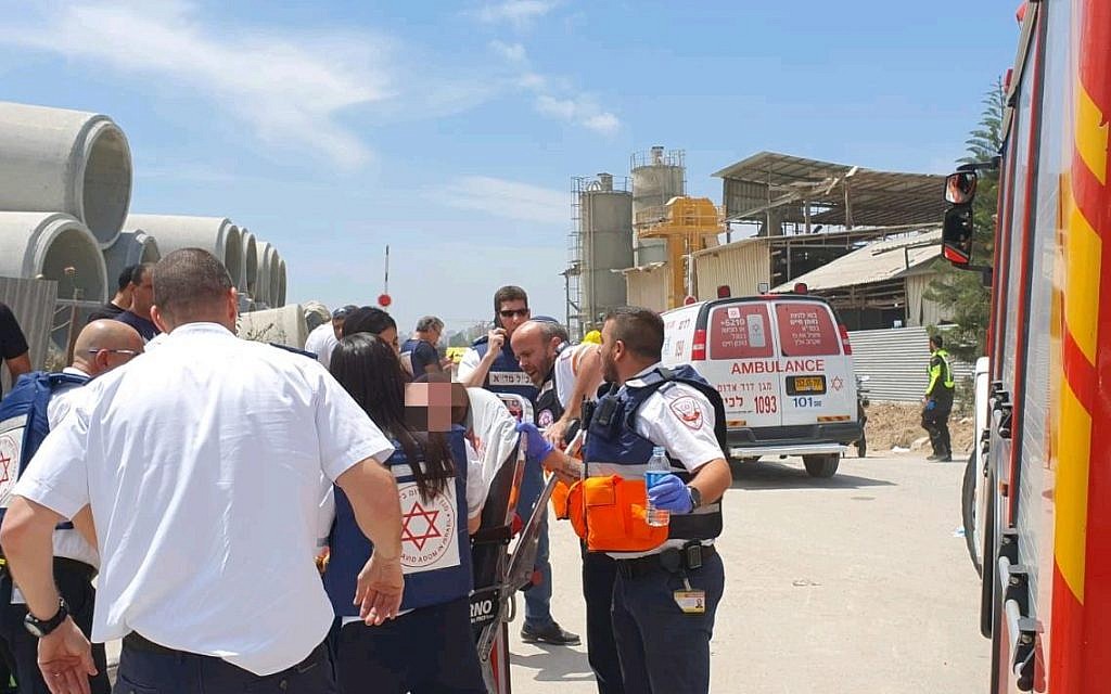 Magen David Adom paramedics treat a factory worker injured in a rocket strike in Ashkelon on May 5, 2019. (courtesy Magen David Adom)